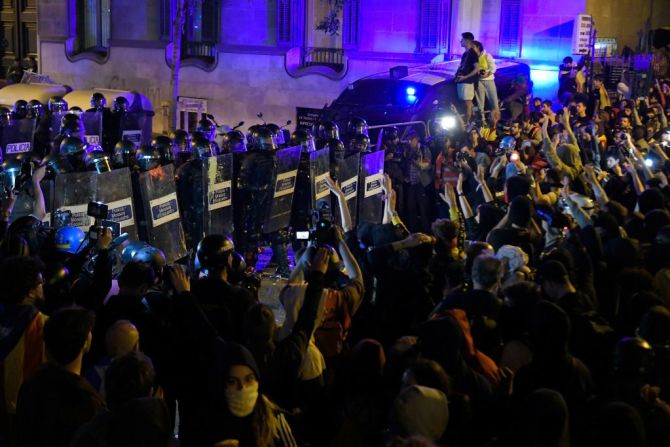 Manifestantes frente a los agentes de la policía catalana, 'Mossos D'Esquadra'. (Photo by LLUIS GENE / AFP).