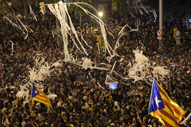 Manifestantes lanzan papel higiénico en una multitudinaria protesta en Barcelona. (Photo by LLUIS GENE / AFP).