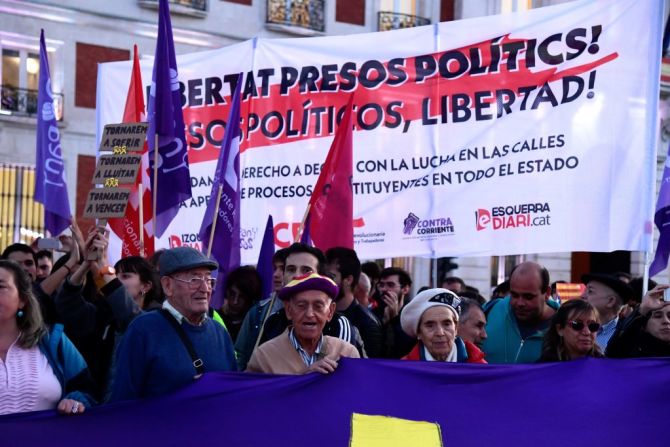 Personas sostienen una pancarta de "Libertad para los presos políticos", durante una manifestación convocada por Coordinadora 25S en Madrid. (Photo by JAVIER SORIANO / AFP).