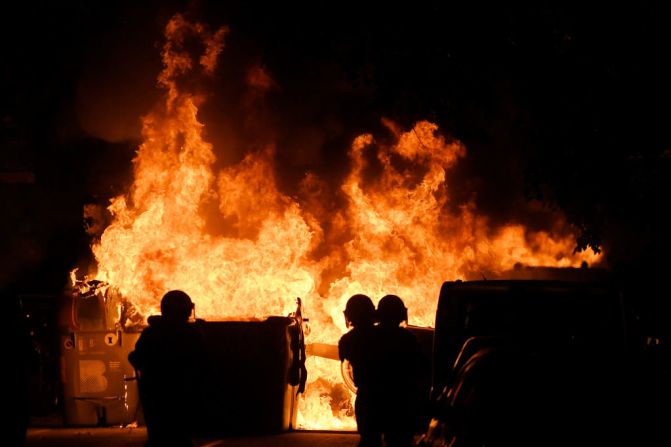 Policía antimotines frente a una barricada en llamas en Barcelona. (Photo by LLUIS GENE / AFP).