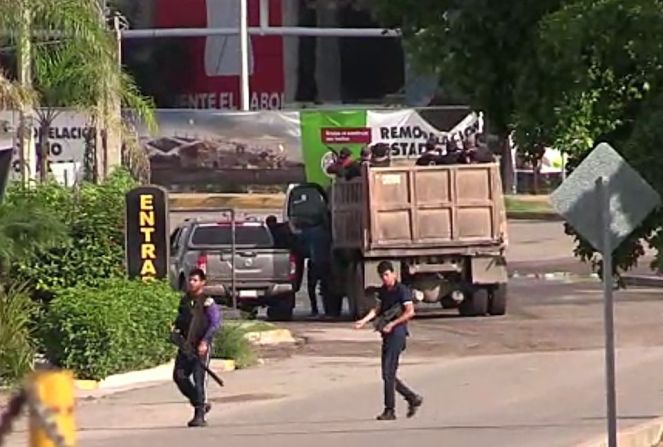 En esta imagen de video de AFPTV se ve a individuos armados en una calle de Culiacán, Sinaloa.