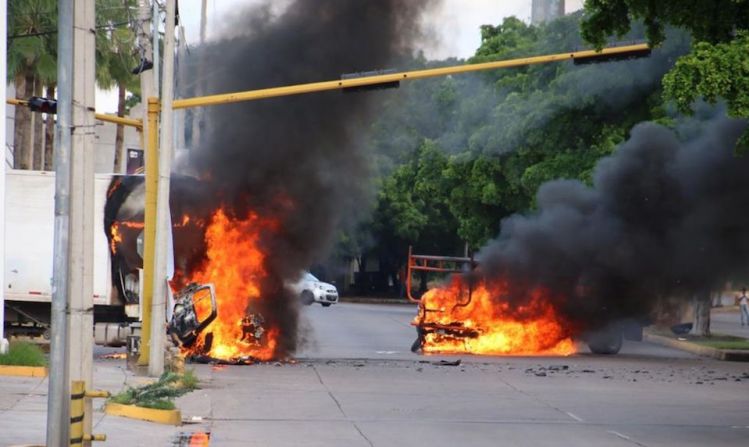 Vehículos incendiados en una calle de Culiacán.