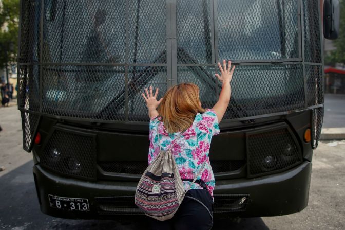 Una mujer se para frente a un vehículo militar durante los disturbios en Santiago de Chile.