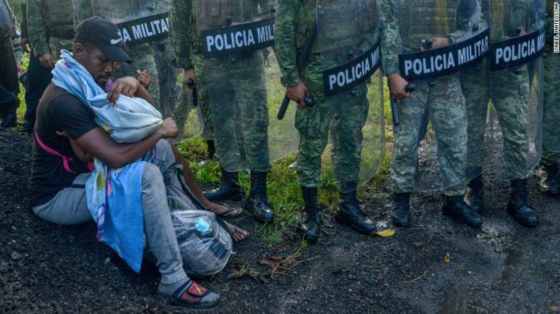 Un inmigrante cuida a un niño rodeado por la Guardia Nacional