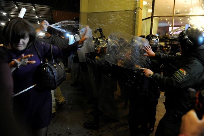 Un grupo de manifestantes se enfrentan a las fuerzas de seguridad afuera del hotel en La Paz donde el Tribunal Supremo Electoral tiene su oficina central en el conteo de votos. De acuerdo con la Agencia Boliviana de Información (ABI), algunos de los manifestantes eran simpatizantes del partido de Carlos Mesa, Comunidad Ciudadana (CC). CNN no ha podido confirmar qué motivó al grupo de personas a quemar el edificio. Hasta el momento, el CC no ha reaccionado al hecho. (Photo by JORGE BERNAL / AFP).