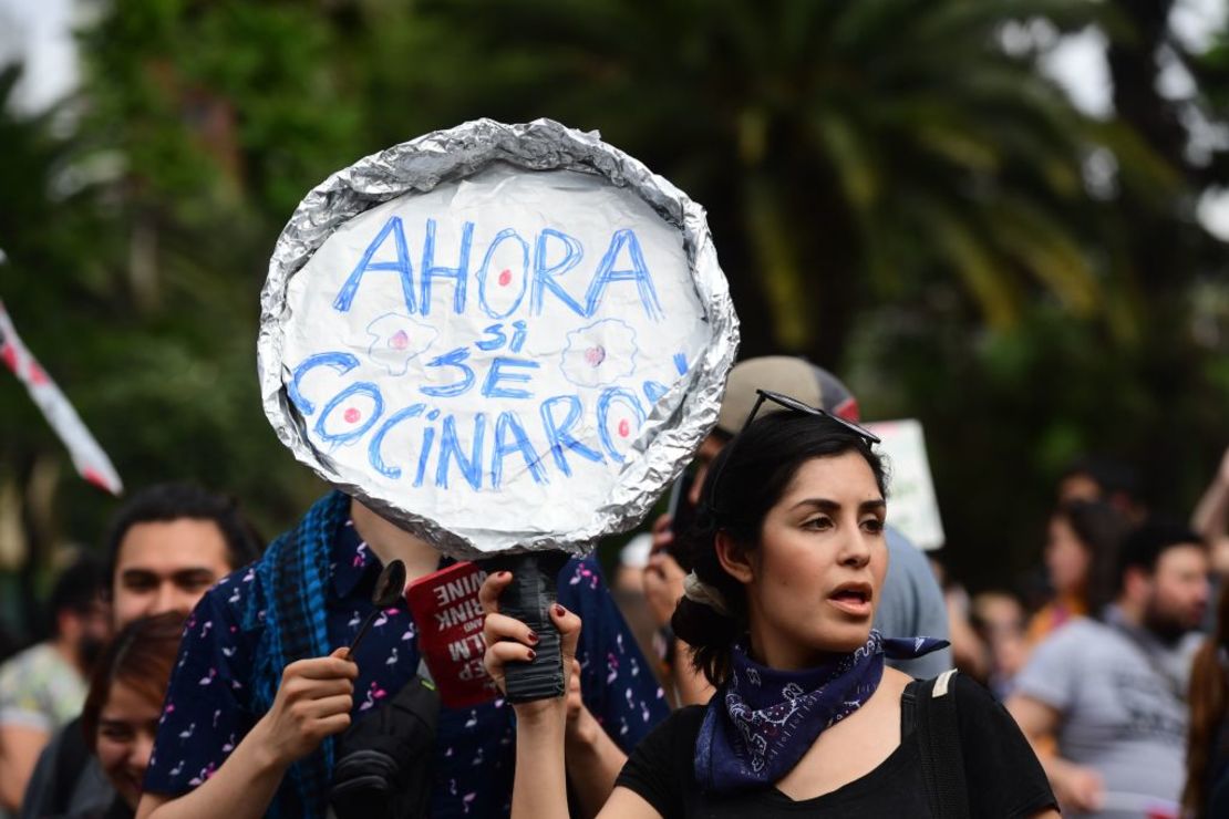 Una mujer muestra un letrero que dice "Ahora sí se cocinados" durante la manifestación en Santiago este viernes, una semana después de que comenzaran las protestas violentas.