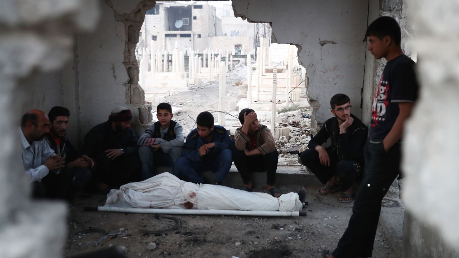 Hombres sirios lloran por el cuerpo de Jihad, de quince años, que murió tras un ataque aéreo del gobierno, en la ciudad de Douma, controlada por los rebeldes, en las afueras de la capital, Damasco, el 14 de noviembre de 2016.