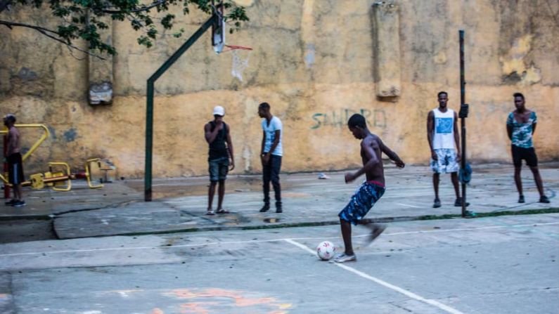 Adolescentes cubanos juegan fútbol en la ciudad después de la escuela. Los habitantes de la isla disfrutan de educación y atención médica gratuita. Con una vasta red de médicos de familia, tienen una mortalidad infantil más baja que la de los estadounidenses y, según algunas estadísticas, tienen una vida útil más larga.