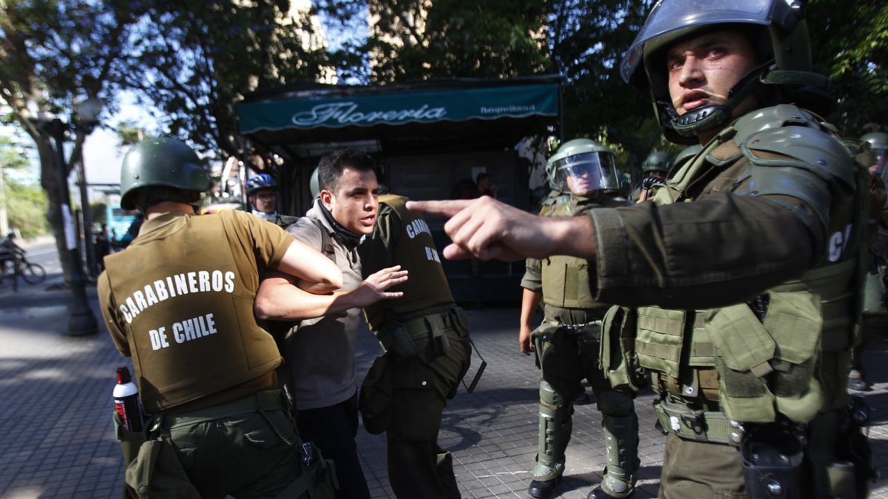 SANTIAGO, CHILE - NOVEMBER 07: Riot police officers arrest a demonstrator during a protest against the government of president Sebastian Piñera on November 7, 2019 in Santiago, Chile. Since October 18, demonstrators are demanding improvements in health care, the pension system, public education, social mobility and are against the privatization of water services, the rise in public transport fares and government corruption. To contain the protests, President Sebastian Piñera had done reshuffle of cabinet and announced yesterday Wednesday 6, that would a raise the minimum salary.