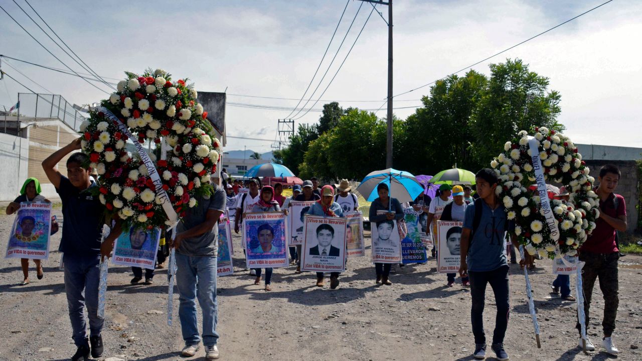 TOPSHOT - Relatives of the 43 missing students of the teaching training school of Ayotzinapa march with their portraits the day after of the fifth anniversary of their disappearance, in Iguala, Guerrero State, Mexico on September 27, 2019. - The Mexican prosecutor-general's office said -last September 18- it will reinvestigate "almost from scratch" the disappearance and suspected massacre of 43 students in 2014, a case that still haunts the country. (Photo by FRANCISCO ROBLES / AFP)