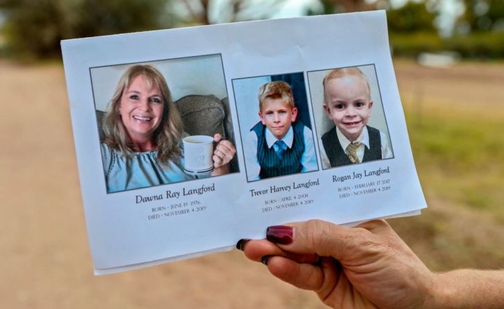 Uno de los dolientes sostiene una tarjeta de recuerdo en el funeral de Dawna Ray Langford y sus hijos Trevor y Rogan.