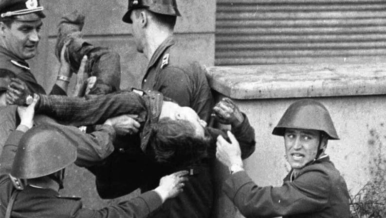 El albañil de Alemania Oriental Peter Fechter, de 18 años, es llevado por los guardias fronterizos después de ser baleado y herido de muerte mientras intentaba huir a Occidente en agosto de 1962. Casi 200 personas murieron intentando cruzar el Muro entre 1961 y 1989. AP