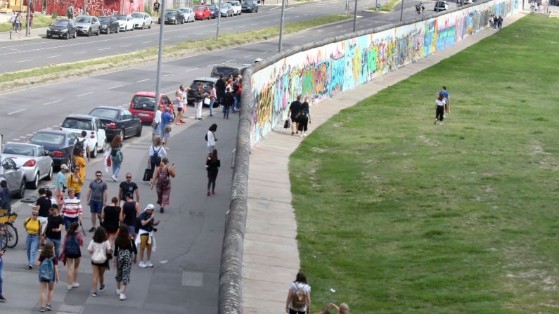 Gente camina a lo largo de la sección más larga que queda del Muro, ahora conocida como East Side Gallery, Galería del Lado Este, en agosto de este año. picture alliance/dpa/Getty Images