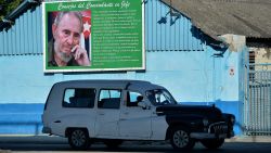 An old American car drives next to a poster of Cuban late leader Fidel Castro in a street of Havana, on November 21, 2019. - Next November 25 marks three years of the death of Cuban leader Fidel Castro, but nevertheless, his iconographic presence is present throughout Cuba. (Photo by YAMIL LAGE / AFP)