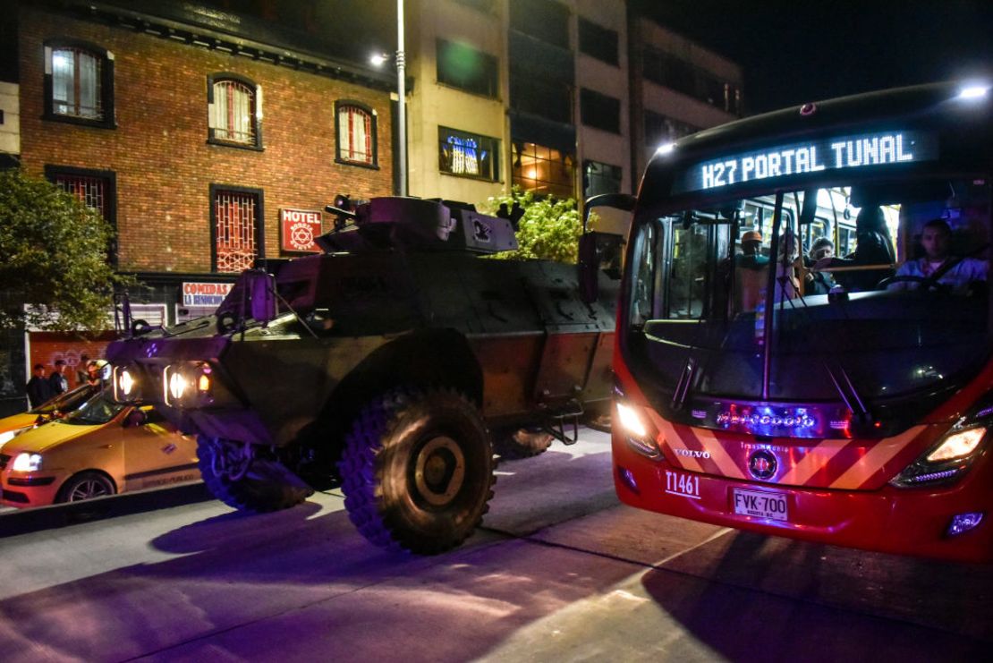 Un tanque militar patrulla cerca de un bus de transporte público durante una vigilia en Bogotá por Dilan Cruz el 26 de noviembre de 2019.