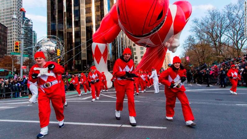 Voluntarios del desfile luchan contra los vientos mientras sostienen un globo gigante de los “Power Rangers” en Columbus Circle.