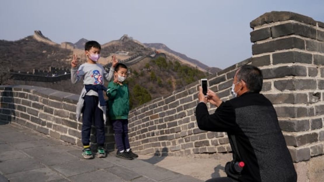 Niños usan mascarillas mientras visitan la Gran Muralla china el 24 de marzo.