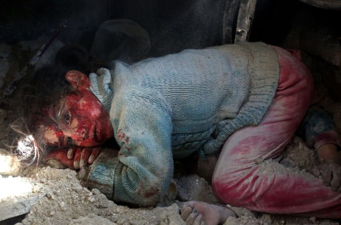 26 de febrero: Hasna'a Qatran, de 6 años, yace junto al cuerpo de su hermana mientras espera ser rescatada de los escombros de un edificio bombardeado en Khan Sheikhoun, Siria. Su hermana, de 3 años, murió en el ataque, al igual que su hermano y un primo de 1 año, según Anas al-Dyab, un voluntario de Cascos Blancos que le tomó la foto a ella y a otros en la escena. Al-Dyab mismo murió en un ataque aéreo en julio. Tenía 23.