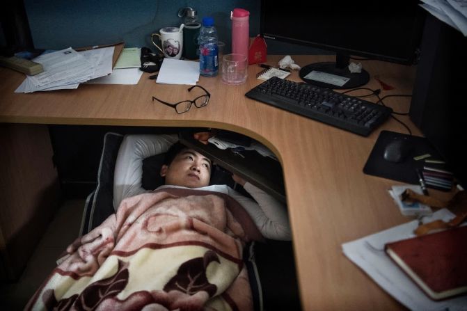 12 de abril: Un empleado de Huawei descansa debajo de su cubículo durante su almuerzo en Shenzhen, China. Esta es una práctica común en muchos lugares de trabajo en China, dijo el fotógrafo Kevin Frayer.