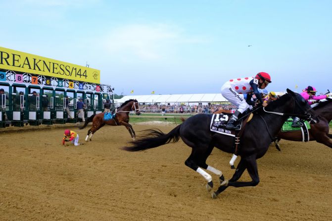 El jockey John Velázquez se cae de Bodexpress al comienzo de la carrera de caballos Preakness Stakes el 18 de mayo. El caballo corrió el resto de la carrera solo.