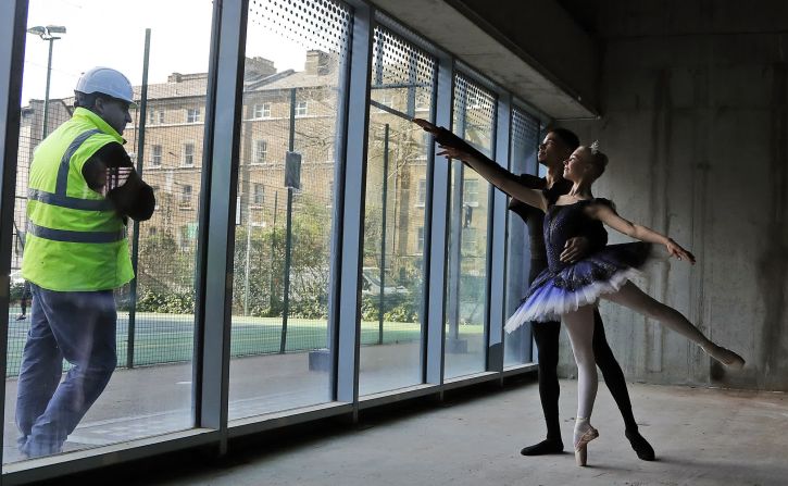 Un trabajador observa a los bailarines de ballet Brandon Brereton y Emily Pohl practicar en Londres el 20 de febrero.