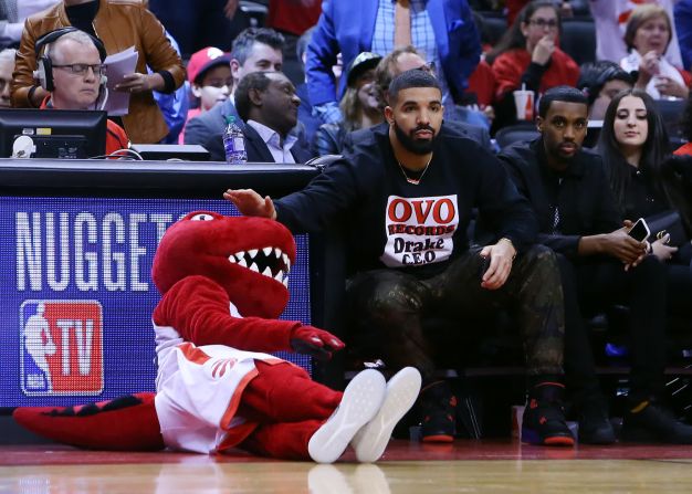 El rapero Drake acaricia a la mascota de los Toronto Raptors mientras mira un partido de desempate de la NBA el 23 de abril. Vaughn Ridley / Getty Images