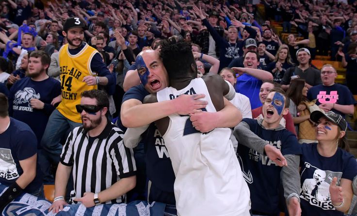 El jugador de baloncesto del estado de Utah Neemias Queta celebra con un fanático después de una victoria en casa contra Nuevo México el 20 de febrero. Eli Lucero / The Herald Journal / AP