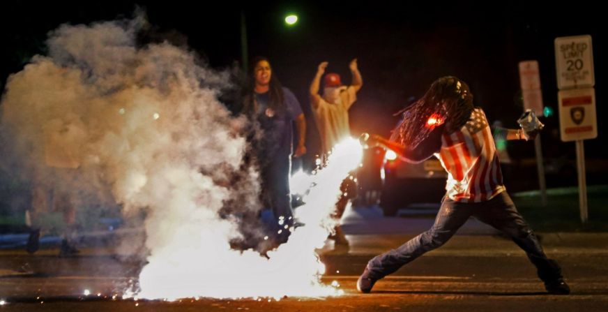 Edward Crawford devuelve un bote de gas lacrimógeno disparado por la policía que intentaba dispersar a los manifestantes en Ferguson, Missouri, en agosto de 2014. Algunas protestas en la ciudad se convirtieron en enfrentamientos entre ciudadanos enojados y la policía después de que Michael Brown, un adolescente negro desarmado, muriera por un disparo de Darren Wilson, un policía blanco.