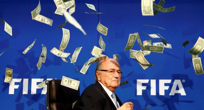 El presidente de la FIFA, Joseph Blatter, en medio de una lluvia de dólares durante una conferencia de prensa en Zurich, Suiza, en julio de 2015. Los billetes fueron lanzados a Blatter por el comediante británico Simon Brodkin, quien luego fue retirado del escenario. Blatter había dirigido el órgano rector del fútbol desde 1998, pero decidió retirarse mientras la FIFA luchaba contra escándalos de corrupción.