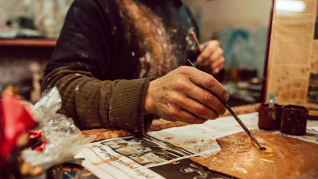 En su pequeña tienda en Quito, Ecuador, Gonzalo Gallardo mezcla pintura para reparar y restaurar figuras religiosas.