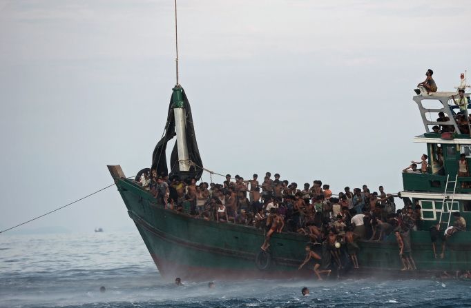 Migrantes rohingya saltan de un bote para recoger los suministros de comida que dejó caer un helicóptero del ejército tailandés en mayo de 2015. El bote, a la deriva en aguas tailandesas, estaba abarrotado de decenas de migrantes. Más de 740.000 rohingya han huido a la vecina Bangladesh después de que el ejército de Myanmar lanzó una campaña de violencia contra la minoría étnica musulmana. Myanmar ha defendido sus acciones, diciendo que estaba apuntando a terroristas.