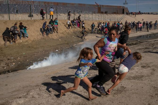 La migrante María Meza y sus hijas gemelas de 5 años, Saira Mejía Meza y Cheili Mejía Meza, huyen del gas lacrimógeno que fue desplegado por agentes de la Patrulla Fronteriza de Estados Unidos cerca de la valla entre México y Estados Unidos. El gas lacrimógeno se disparó después de que algunos inmigrantes en el lado mexicano de la frontera invadieron la policía e intentaron cruzar la frontera en noviembre de 2018. El incidente marcó una escalada de tensiones que se habían ido acumulando desde que grupos de migrantes centroamericanos comenzaron a llegar a la ciudad fronteriza mexicana de Tijuana, atrayendo amenazas del presidente de Estados Unidos, Donald Trump, de cerrar la frontera.