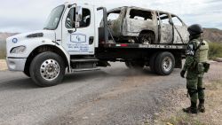 A worker lifts to the tow truck the burnt van where five of the nine members of the Mexican-American LeBaron family were killed, in the Sonora mountain range, Mexico, on November 6, 2019. - Mexican authorities said Wednesday they believe a drug cartel called "La Linea" was responsible for the murder of the three women and six children, saying the massacre was committed with American-made ammunition. Eight other children managed to escape, six of them wounded. (Photo by Herika Martinez / AFP)