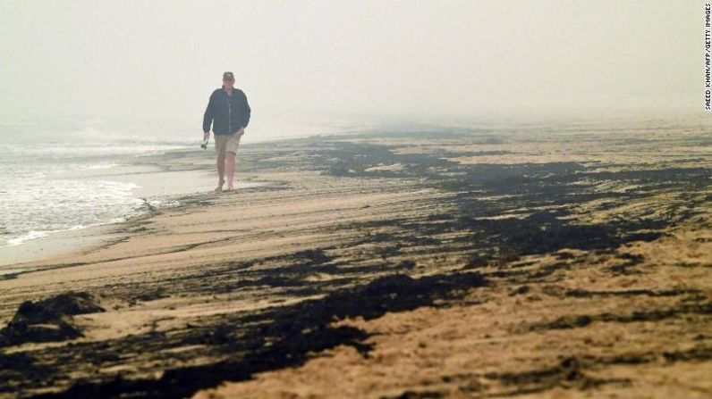 Un hombre camina entre cenizas dejadas por los incendios forestales en una playa en Merimbula, el 5 de enero. Saeed Khan / AFP / Getty Images