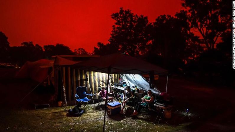 El cielo se pone rojo durante el día en Mallacoota, Australia. La gente en el parque de autocaravanas Foreshore permanece en el sitio en lo que será un día de severas condiciones de fuego con grandes incendios aún fuera de control al norte de la ciudad. Justin McManus / The Age / Fairfax Media a través de Getty Images