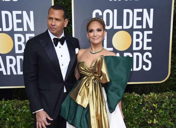 JLo llegó a los Golden Globe luciendo un vestido metalizado con un gran moño. Junto a ella su prometido, ARod.