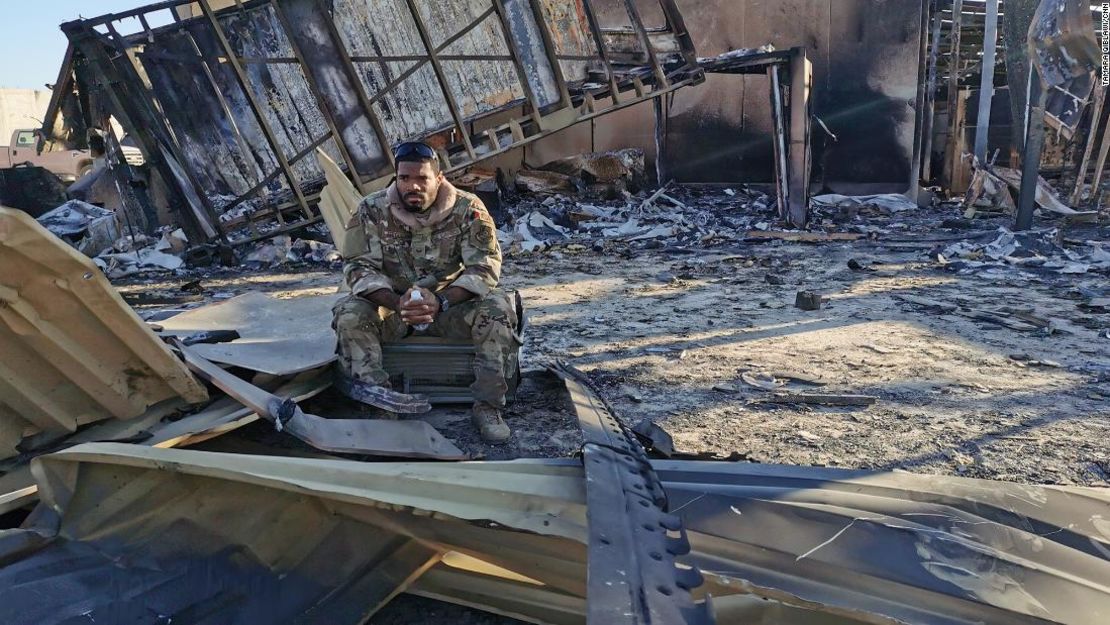 El sargento Ferguson se sienta en medio del metal carbonizado del lugar donde quedaba la unidad de vivienda para pilotos y operadores de drones que fue destruida.