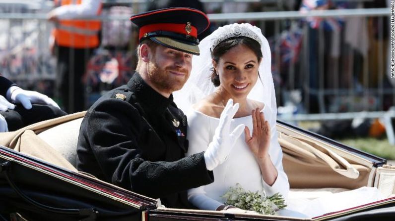 Justo después de la boda, los recién casados saludan durante su procesión de carruajes en Windsor, Inglaterra. Aaron Chown / WPA Pool / Getty Images