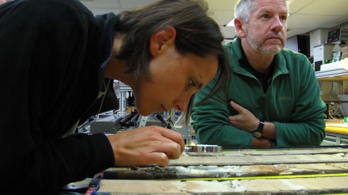 Investigadores observan núcleos de roca extraídos del lecho marino.