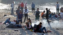 Central American migrants -mostly Hondurans heading in a caravan for the US- wake up on the bank of the Suichate River, where they spent the night, in Ciudad Hidalgo, Mexico, after crossing from Tecum Uman, Guatemala, on January 21, 2020. - Some 500 Central Americans, from the so-called "2020 Caravan", crossed Monday from Guatemala to Mexico, but over 400 were intercepted when National Guardsmen fired tear gas at them. (Photo by ALFREDO ESTRELLA / AFP)