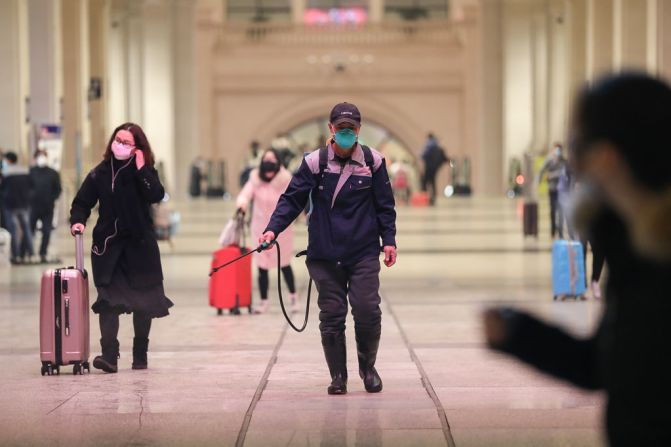 Desinfectan la estación de trenes en Wuhan, el centro del brote del coronavirus donde se urgió a las personas no ir a la ciudad. (Photo by STR / AFP) / China OUT.