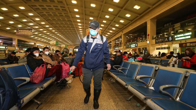 Un trabajador de la estación de trenes Hankou en Wuhan, China, desinfecta las sillas de las salas de espera. (Photo by STR / AFP) / China OUT.