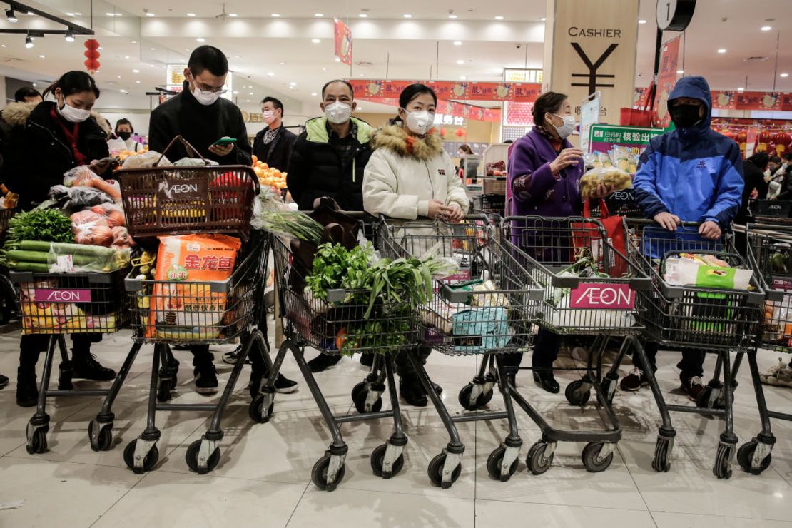 Residentes de Wuhan, la ciudad donde se originó el virus, hacen fila en un supermercado para abastecerse. La ciudad está bajo cierre y el transporte público ha sido cerrado.