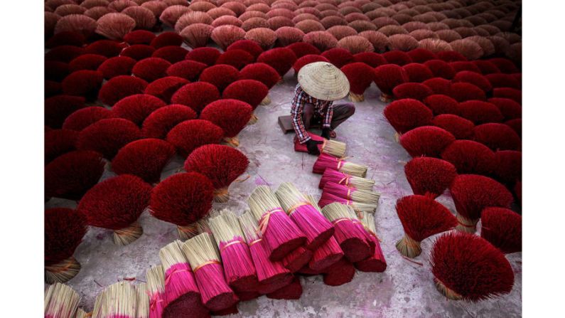 Mención especial, categoría El arte de viajar: la imagen de Tran Tuan Viet, en la que un trabajador recolecta paquetes de incienso en Hanoi, Vietnam, también recibió elogios.