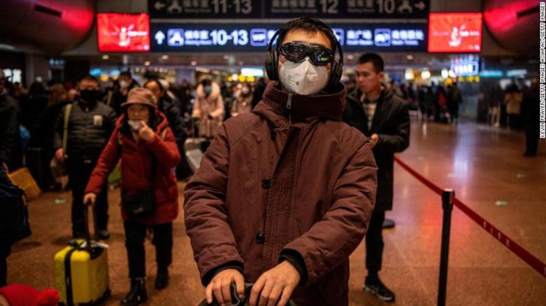 Un hombre usa una máscara de protección y gafas antes de abordar un tren en la estación de Beijing el 23 de enero de 2020.