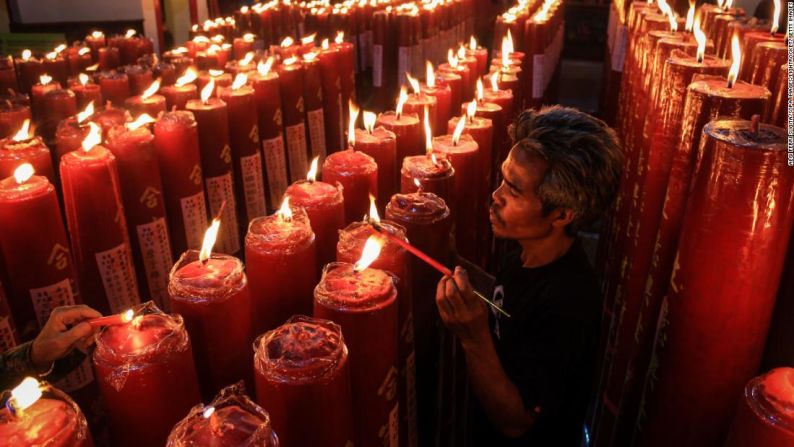 Un hombre enciende velas durante las celebraciones de medianoche del Año Nuevo Lunar en el Templo Dharma Ramsi en Bandung, Indonesia, el sábado 25 de enero.