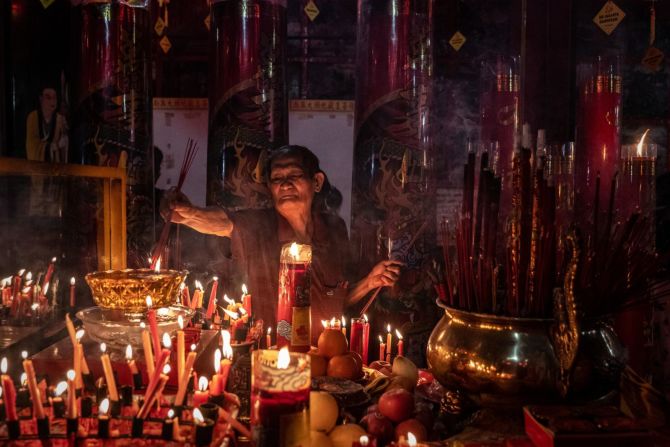 Un hombre quema varitas de incienso durante las celebraciones de la víspera del Año Nuevo Lunar en Fuk Ling Miau en Yogyakarta, Indonesia.