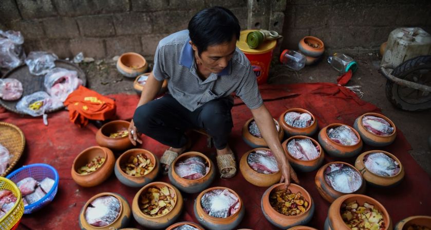 Un hombre prepara carpa en ollas de barro para cocinar en la provincia de Ha Nam el martes 21 de enero. El pescado estofado es un manjar popular durante el Año Nuevo Lunar, o la temporada del Tet, en el norte de Vietnam.