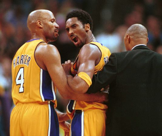 Bryant es contenido por su compañero de equipo Ron Harper, a la izquierda, y el entrenador asistente Jim Cleamons después de una confrontación con el guardia de los New York Knicks, Chris Childs, el 2 de abril de 2000, en el Staples Center. Ambos jugadores fueron expulsados ​​y los Lakers derrotaron a los Knicks 106-82.