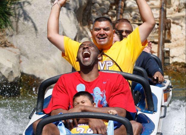 Bryant se divierte con Jonathan Guerrero, de 4 años, y su padre, David Guerrero de Pomona, California, en Disneyland el 18 de junio de 2009, en Anaheim, California. Los Guerrero estuvieron entre los miles de fanáticos de los Lakers que asistieron a un desfile especial de Disneyland en honor al 15° Campeonato Mundial de los Lakers.